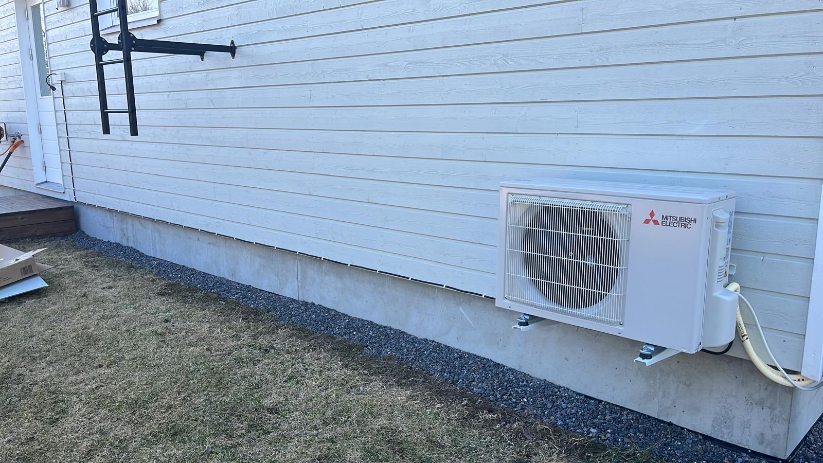 ilmalämpöpumpun ulkoyksikkö asennettuna omakotitalon seinälle